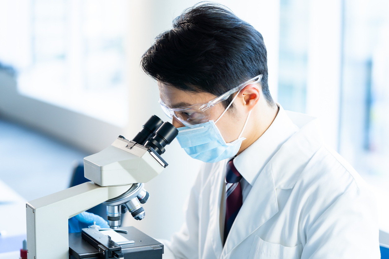 顕微鏡で品質を確認する研究員